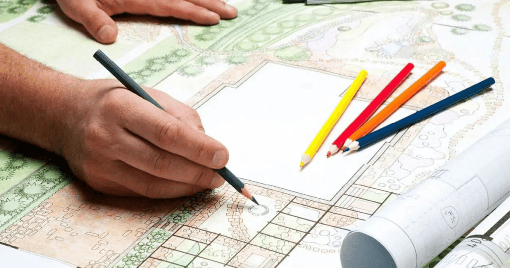 A person is drawing on a piece of paper with colored pencils.